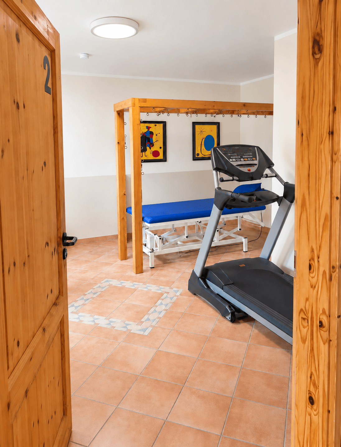 Behandlungsraum mit Therapieliege und Laufband